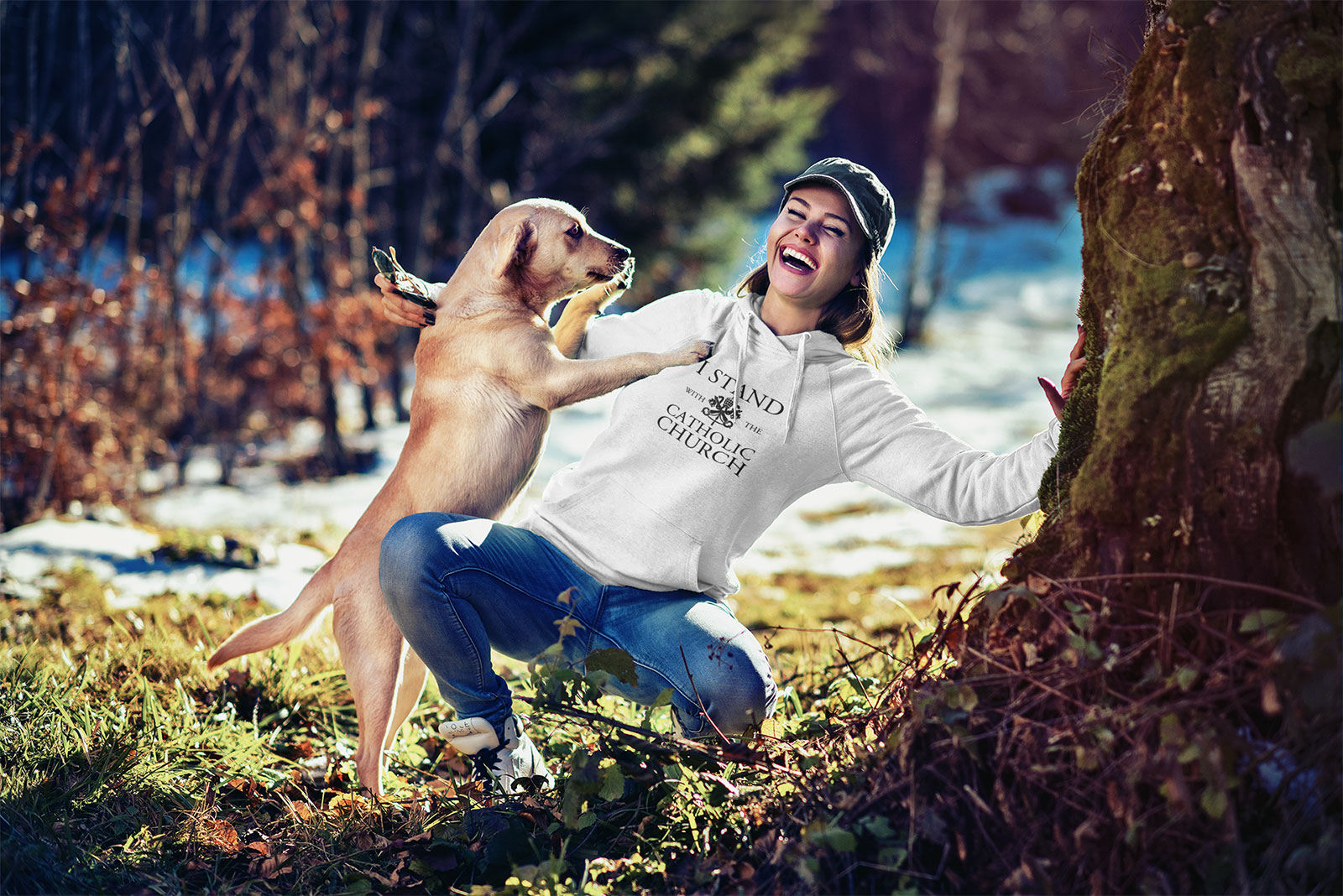 Woman wearing hooded sweatshirt while playing with dog.